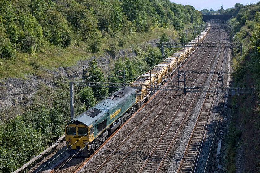 66563 (DIT), 08.50 Rugby Long Lawford Junction-Willesden HBOC (6Y15), Roade cutting 
 Quite why 66563 was switched off and providing no assistance pushing the gargantuan 08.50 Long Lawford Junction to Willesden Junction HOBC jumbo drain train I do not know. This left 66514, out of sight in this image, leading the entire train on its own and accounts for why it was moving at little more than walking pace here in Roade cutting! 
 Keywords: 66563 DIT dead in tow 08.50 Rugby Long Lawford Junction-Willesden HOBC 6Y15 Roade cutting Freightliner