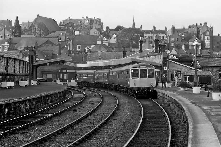 Class 104 hybrid DMU, 16.23 Whitby-Middlesbrough, Whitby station 
 A four-car Class 104/101 DMU waits at Whitby station to work the 16.23 service to Middlesbrough. There was once a fine overall roof that spanned the tracks but, as can be seen, it was removed by British Railways in 1953 with the somewhat disappointing awnings constructed. Back in 1980 Whitby station was probably at its lowest ebb looking very run-down and would have made an ideal candidate for BR to knock down completely and build a small bus shelter affair. However, things have improved with it going through a bit of a renaissance now entertaining train services from and to the North Yorkshire Moors Railway. It is now Grade II listed and has been tasteful restored. 
 Keywords: Class 104 hybrid DMU 16.23 Whitby-Middlesbrough, Whitby station