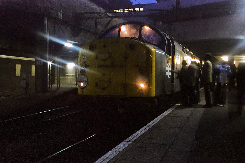 40024, return leg of the Pennine Explorer, Rotherwood Exchange sidings-Cardiff Central, Birmingham New Street station 
 By way of a comparison of the last picture, I have removed the flash from the camera and tried my luck at a time exposure. There is some movement in the image so I am not sure what I used to steady the camera as I did not posses a tripod. This image did not make the original collection due to its poor quality but after some work in Photoshop a pretty atmospheric picture has been produced. It shows 40024 being cabbed by a line of young enthusiasts as it waits to be detached from the Pennine Explorer railtour as it returns to Cardiff Central taken at Birmingham New Street. 
 Keywords: 40024 Pennine Explorer Rotherwood Exchange sidings-Cardiff Central Birmingham New Street station