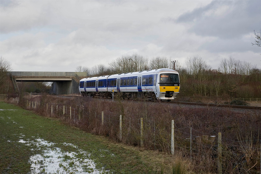 165015, CR 14.18 Bicester Town-Oxford (2T15), Wendlebury SP561182 
 165015 works the SuO 14.18 Bicester Town to Oxford service past Wendlebury having just passed under the M40 motorway. In just under a week's time, the line will be closed to passengers and it will be torn up and completely rebuilt to modern double-track standards. If all goes to plan, trains will be running again in two years time directly between Oxford and Marylebone with a brand new station built at Bicester replacing the tiny Town station. I will endeavour to revisit this spot and recreate this view once the new line is open but I suspect it will be spoilt by palisade fencing! 
 Keywords: 165015 14.18 Bicester Town-Oxford 2T15 Wendlebury SP561182