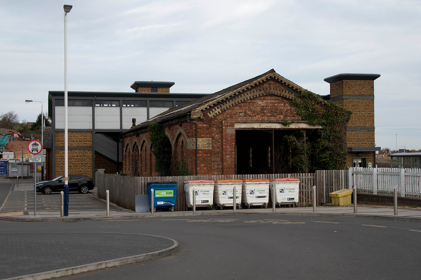 Former goods shed, Wellingborough station 
 I bet that the planners and developers curse the old c.1857 Wellingborough goods shed as it it occupies a prime site between the new station car park and the station. However, quite rightly, it's a listed structure and, as such, it cannot be demolished or altered in any way without a great deal of planning and the agreement of Historic England and a number of other agencies. Designed by C.H. Driver for the Midland Railway its is built of red brick with yellow and blue brick dressings and slate roof. 
 Keywords: Former goods shed Wellingborough station