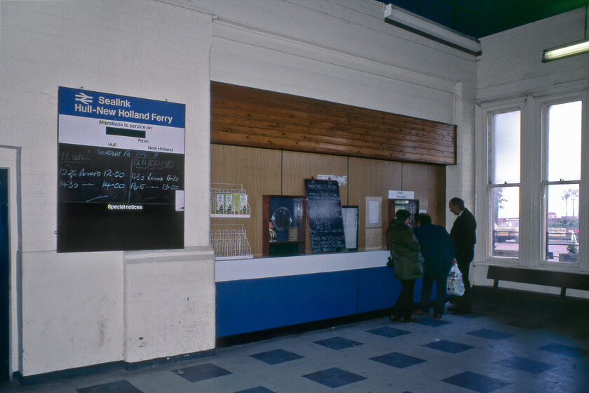 Ticket office, Hull Corporation Pier 
 The interior of the booking hall of Hull Corporation Pier station is seen with three passengers purchasing tickets to make the crossing on MV Farringford to New Holland Pier. The ticket booth would close completely in exactly a week's time with the withdrawal of the ferry service following the opening of the Humber bridge. Close examination of the notice boards reveals some alterations to the ferry timings on the large one with information on the closure on the small one. There are also some leaflets in the wire holder encouraging travellers to let the 'train take the strain' with the face of the disgraced entertainer and paedophile Jimmy Saville peering rather eerily out. 
 Keywords: Ticket office Hull Corporation Pier