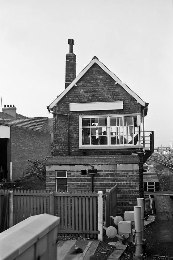 Middlesbrough signal box (NER, 1877) 
 Taken from a departing train that I was travelling on to Darlington Middlesbrough signal box is seen despite the plain white name board! The box is a simpler version of the NER's earlier design dating from 1872. The box is still in use today (at the time of writing in 2020) operating an IFS panel that was installed in 1978. I am not at all sure what the signalling infrastructure is in the foreground with its large counterweights, can anybody advise? I took a photograph of this box during my most recent visit in 2019, the building to the left that I believe to be a garage with its large concrete lintel is still exactly the same, see.... https://www.ontheupfast.com/p/21936chg/26273794604/middlesbrough-signal-box 
 Keywords: Middlesbrough Signal Box