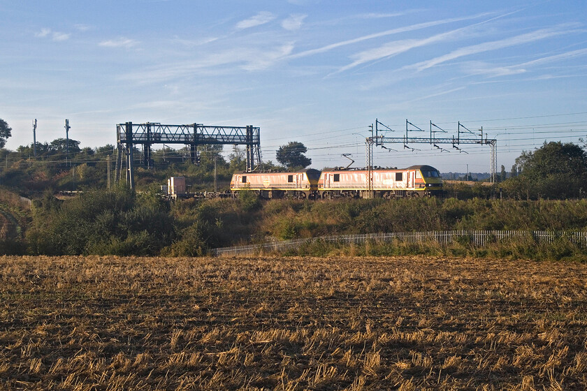 90003 & 90044, 02.57 Felixstowe North-Garston (4M45, 45E), between Roade & Ashton 
 Matching pair 90003 and 90044 pass through the Northamptonshire countryside just south of Roade on a perfect September morning hauling the 4M45 02.57 Felixstowe to Garston Freightliner service. Unfortunately, I have not quite framed the doubled-headed locomotives quite right but side-on opportunities are limited around this location a situation exacerbated by the low angle of the rising sun. 
 Keywords: 90003 90044, 02.57 Felixstowe North-Garston 4M45 between Roade & Ashton Freightliner