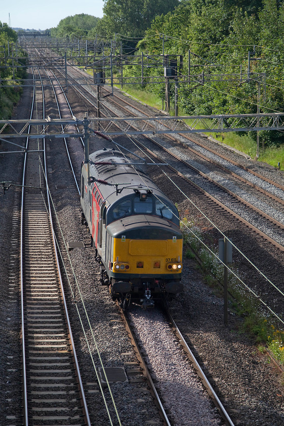 37611, 05.29 Leicester Northampton EMD LE (Via Weedon loop, reverse at CMK), Victoria Bridge 
 Some four hours after it left Leicester, 37611 'Pegasus' is approaching its destination! Due to the closure of the line between Northampton and Rugby the 05.29 Leicester to Northampton EMD light engine working has run south via the fast to Milton Keynes where it reversed and headed back to Northampton as shown here passing Victoria Bridge. It was to collect a class 350 from the Kingsheath Depot for London Northwestern and take it Long Marston for scheduled body repairs. Just an aside, this circuitous route could have been avoided if the 1981 closed Market Harborough to Northampton line had remained open. Not ever a line that is likely to be considered for re-opening, but it's a thought! 
 Keywords: 37611 05.29 Leicester Northampton EMD LE Victoria Bridge