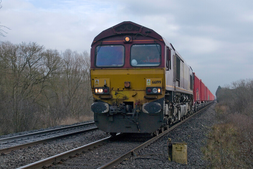 66199, 12.12 Limbury Road-Dowlow Briggs Sidings (4M84, 4E), Wymondham crossing 
 I can rest assured my readers that I am in a safe and legal position here at Wymondham crossing, in fact, standing close to the crossing keeper! 66199 approaches the crossing leading the 12.12 Limbury Road to Dowlow Briggs 4M84 empty aggregates working. 66199 is one of the increasingly few members of the class still in its 'as-built' EWS livery but this one has lost it 'three beasties' from the panel below the cab windows. 
 Keywords: 66199, 12.12 Limbury Road-Dowlow Briggs Sidings (4M84, 4E), Wymondham crossing.jpg