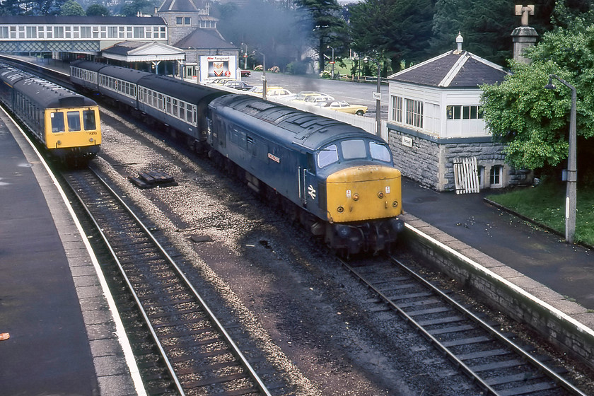 P473, Class 118 DMU & 45055, 13.50 Exeter St. David`s-Paignton, Torquay station 
 An easy job for 45055 'Royal Corps of Transport' working the 13.50 Exeter to Paignton local stopper! It would have had little difficulty getting three Mk.1 coaches away from Torquay station as seen here passing the lovely signal box and a pair of Class 116 DMUs heading in the other direction. The box has not always been located on the platform. Originally it was a stand-alone box with the platform finishing approximately level with the first coach with a west-facing bay platform slotting into the right of the train where the line of 1970s cars are parked. Notice the area of tack in front of 45055 heavily polluted by leaking fuel and oil from countless diesels that will have been coming to a halt at this spot over the years! 
 Keywords: P473 Class 118 DMU 45055 13.50 Exeter St. David`s-Paignton Torquay station Royal Corps of Transport