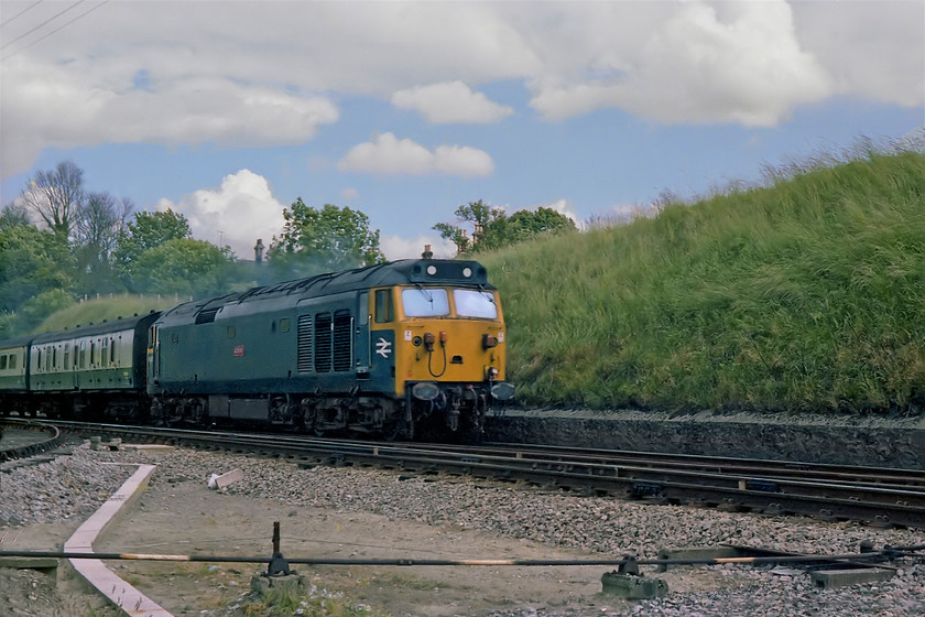 50045, unidentified down working, Savernake Junction 
 Taken with my back to the switched out signal box at Savernake West Junction, 50045 'Achilles' surmounts the bank and begins its decent towards Pewsey. It is heading an unidentified down working. Yes, as the box was switched out, we did permit ourselves access to the lineside; not something I would ever consider today but it was a different time forty years ago. 
 Keywords: 50045 down working Savernake Junction