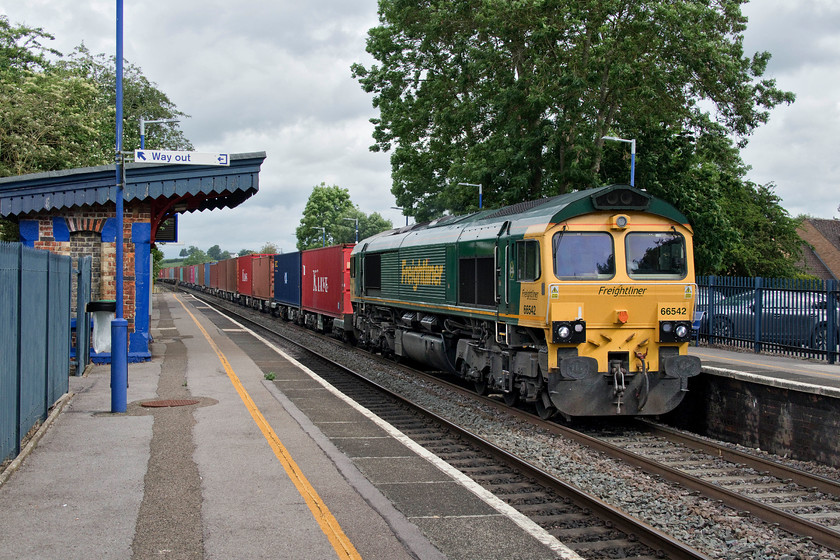 66542, 07.03 Birch Coppice-Southampton (4O05), King`s Sutton station 
 66542 sweeps through King's Sutton station leading the 07.03 Birch Coppice to Southampton Freightliner. On the down platform remains the original Great Western waiting shelter complete with its canopy roof; a remarkable survivor. King's Sutton station is one of only six in the county of Northamptonshire and, out of all of them is the least used with 65 400 passengers using the station during 2017/18. As such, it also featured in one of All the Stations least used stations videos, see..... https://www.youtube.com/watch?v=inbE3xgJrVQ 
 Keywords: 66542 07.03 Birch Coppice-Southampton 4O05 King`s Sutton station