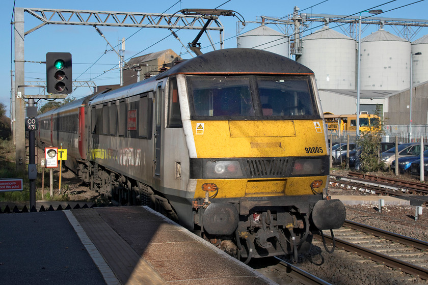 90005, GA 13.30 London Liverpool Street-Norwich (1P32, 13L), Diss station 
 90005 'Vice-Admiral Lord Nelson' propels the 13.30 Liverpool Street to Norwich out of Diss station on a beautiful autumn afternoon. The grain silos belonging to Frontier Agriculture, are seen in the background, these were once rail-linked with the sidings now used by the PW department. 
 Keywords: 90005 GA 13.30 London Liverpool Street-Norwich 1P32 Diss station