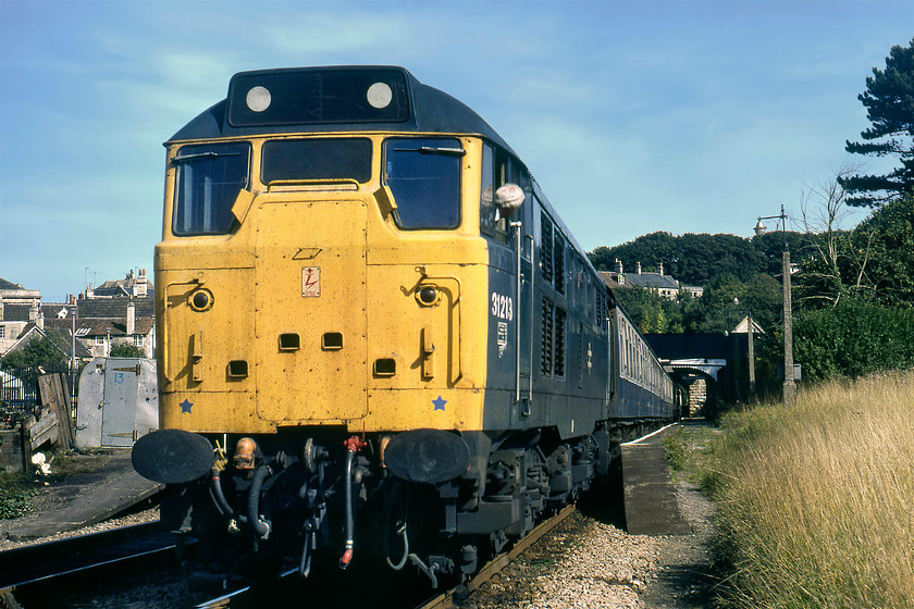 31213, 12.07 Portsmouth Harbour-Bristol Temple Meads, Bradford-on-Avon station 
 A photograph taken in an identical position to one taken some nine months previously but in very different weather.... https://www.ontheupfast.com/v/photos/21936chg/25511221604/x33027-08-56-portsmouth-harbour-bristol 31213 waits to get away from Bradford-on-Avon. It is leading the 12.07 Portsmouth Harbour to Bristol Temple Meads, a train composed of a smart rake of Mk. I stock. Whilst the driver seems pre-occupied with getting the RA from the guard he does not seem bothered by a fifteen-year-old boy off the end of the platform and taking a photograph; how different to things today! 
 Keywords: 31213 12.07 Portsmouth Harbour-Bristol Temple Meads Bradford-on-Avon station