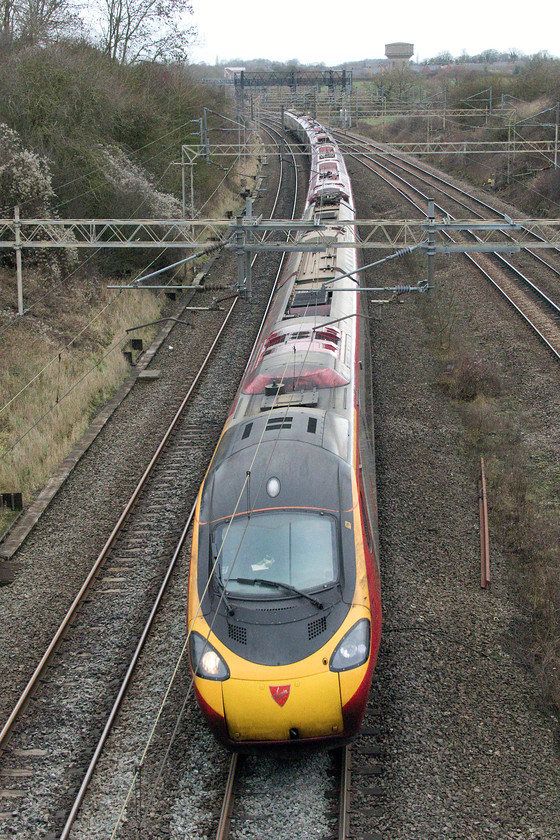 390124, VT 10.35 Manchester Piccadilly-London Euston (1A24, 6L), Victoria bridge 
 390124 'Virgin Venturer' is about to speed under Victoria bridge as it enters the last sixty miles of its journey working the 10.35 Manchester Piccadilly to Euston. It's a particularly dull winter's day but at least it's the winter solstice and the darkness will begin to get a little shorter starting off by just less than a minute per 24 hours. 
 Keywords: 390124 10.35 Manchester Piccadilly-London Euston 1A24 Victoria bridge