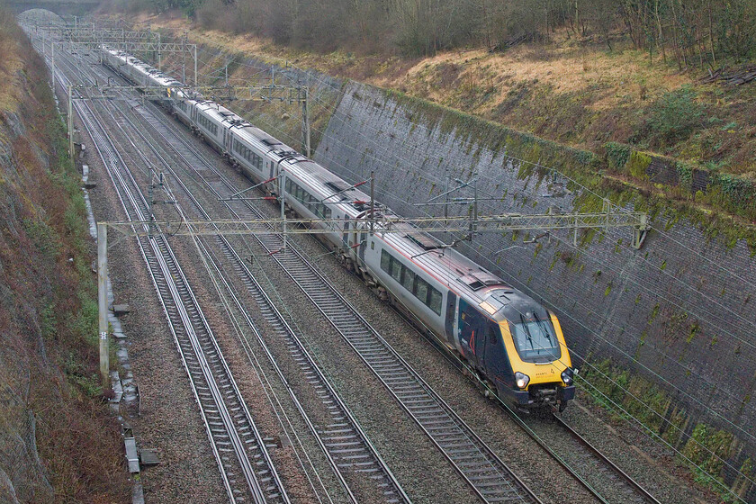 221102 & 221113, VT 11.40 London Euston-Birmingham New Street (9G18, 1L), Roade cutting 
 Every time I take a photograph of an AWC Voyager I wonder how long I will be able to do so! Their replacement on the WCML is now over two years overdue and still, they run! 221102 and 221113 head north through Roade cutting working the 11.40 Euston to Birmingham service. Is there really not a spare Pendolino kicking around that could (and should) have worked this service entirely under the wires? 
 Keywords: 221102 221113 11.40 London Euston-Birmingham New Street 9G18 Roade cutting AWC Avanti West Coast Voyager