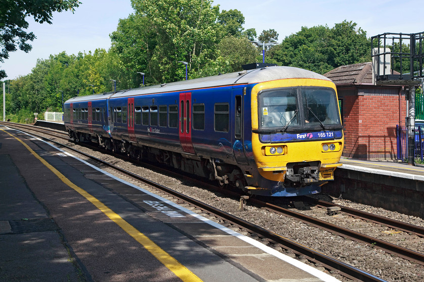 165121, GW 10.13 Newbury-Reading (2K47, 5L), Midgham station 
 The sight of these 'Turbos' as they are referred toon this line is now somewhat limited. The electrification of this line is now wildly over-time and budget and by now it should have been completed with brand new shiny units silently gliding in and out of these stations. Apart from one electrification mast in the very background, there no evidence of the electrification process here at Midgham as 165121 pauses with the 10.13 Newbury to Reading service. 
 Keywords: 165121 2K47 Midgham station