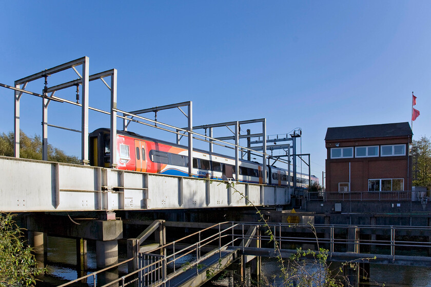 158862, EM 09.52 Liverpool LS-Norwich (1L08), Trowse swing bridge 
 158862 rattles across Trowse swing bridge working the 09.52 Liverpool to Norwich East Midlands Trains train within half a mile of journey's end. In this view, the unusual design of the bridge is clear to see with its fixed overhead conductor rail instead of a wire providing AC power for the electric Greater Anglia trains. This is the only electrified swing bridge in the UK being a particulary rare type of structure with one other in Europe and others in North America. 
 Keywords: 158862 09.52 Liverpool Lime Street-Norwich 1L08 Trowse swing bridge East Midlands Trains