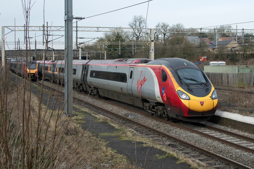 Class 221, VT 12.10 London Euston-Chester (1D86, cancelled from Rugby) & 390103, VT 11.15 Manchester Piccadilly-London Euston (1A27, 2L), site of Castlethorpe station 
 A class 221 heads north on the up fast forming the 12.10 Euston to Chester. Unfortunately, something went wrong a little further north from here at Castlethorpe as the train was terminated at Rugby. According to Real Time Trains, it was due to 'a problem with the electrical equipment' - whatever that is supposed to mean? Meanwhile, 390103 'Virgin Hero' heads south with the 11.15 Manchester to Euston that arrived just two minutes late. Notice the neat reflection of the the Voyager on the side of the Pendolino. 
 Keywords: Class 221 12.10 London Euston-Chester 1D86 cancelled from Rugby 390103 11.15 Manchester Piccadilly-London Euston 1A27 site of Castlethorpe station