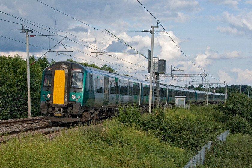 350376 & 350372, LN 17.56 London Euston-Birmingham New Street (1Y61, 5L), Wilson's Crossing 
 The 17.56 Euston to Birmingham New Street London Northwestern service accelerates away from Northampton at Wilson's crossing worked by 350376 and 350372. The train is in weak sunshine with the stubborn area of cloud seen above the train spoiling the mid-summer's day party! 
 Keywords: 350376 350372 17.56 London Euston-Birmingham New Street 1Y61 Wilson's Crossing London Northwestern Desiro