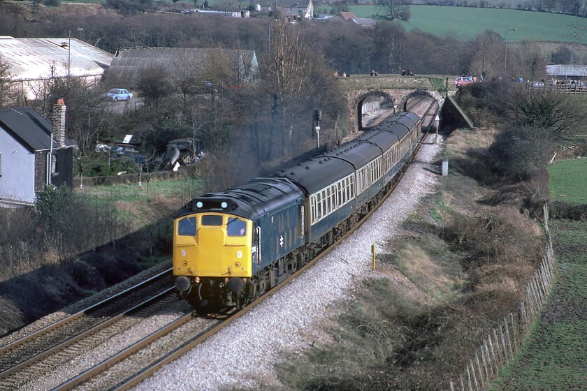 25042, 15.10 Cardiff Central-Crewe (1M75), Caerleon ST330923 
 In the days before Class 33s worked the Marches route Class 25s were the mainstay of operations. Making its way past Caerleon 25042 leads the 1M75 15.10 Cardiff to Crewe service composed of a rake of six Mk. 1 coaches providing plenty of comfortable seats for the passengers. Notice the enthusiasts gathering on the B4236 overbridge in anticipation of the returning steam-hauled Welsh Marches Express charter. Remarkedly, an almost identical photograph is reproduced on page 14 of L. A. Nixon's book British Rail in Colour published in 1982 ISBN 0 7106 0224 3 meaning that the great man must have been standing right next to me! By pure coincidence, I have a signed copy of this book in my collection. 
 Keywords: 25042 15.10 Cardiff Central-Crewe 1M75 Caerleon ST330923 Mk. 1 stock Rat