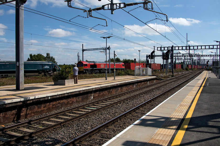 802101, GW 12.00 Oxford-London Paddington (1P26, RT) & 66150, 09.47 Southampton Western Docks-Birch Coppice (4M71), Didcot Parkway station 
 Despite Didcot's recent transformation and the virtually complete change in trains that pass through, it remains a mecca for spotters. I counted at least half a dozen on the station, most were of the older generation it has to be said! In this image, two of them observe 802101 passing on the avoider line with the 12.00 Oxford to Paddington whilst 66150 heads north on the down line leading the 4M71 09.47 Southampton Western Docks to Birch Coppice Freightliner. This picture also illustrates the ruinous effect of the installation of the wiring and all its paraphernalia for the railway photographer. 
 Keywords: 802101 12.00 Oxford-London Paddington 1P26 66150 09.47 Southampton Western Docks-Birch Coppice Didcot Parkway station