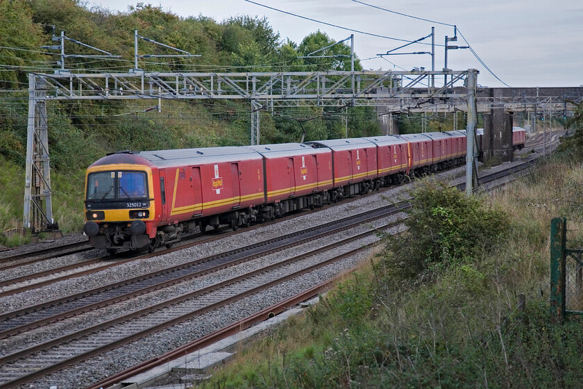 325012, 325013 & 325015, 16.22 Willesden-Shieldmuir Mail Terminal (1S96), Roade 
 The daily (M-F) 1S96 Royal Mail train passes Roade worked, as is usually the case by a trio of Class 325 units. In this case, 325012 leads 325013 with 325015 bringing up the rear. Since the Royal Mail postal trains of old finished nearly ten years ago this is the only route that Mail is conveyed on. 
 Keywords: 325012 325013 325015 16.22 Willesden-Shieldmuir Mail Terminal 1S96 Roade Royal Mail 325012 325013 325015 16.22 Willesden-Shieldmuir Mail Terminal 1S96 Roade