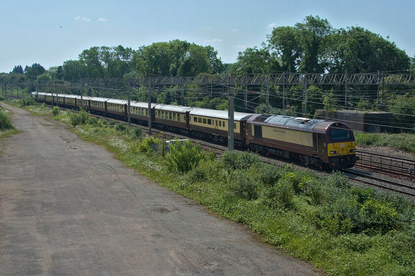 67021 & 67024, 08.43 Stewarts Lane-Hamilton EG Steel (5Z60, 7E), site of Roade station 
 Unfortunately, taken against the strong summer light the 5Z60 08.43 Stewarts Lane to Hamilton EG Steel empty stock working is seen passing through Roade. Leading the rake of Belmond Pullman stock is 67021 with 67024 bringing up the rear. As EG Steel works on all types of railway stock undertaking repairs to to corrosion and general repairs to frames I suspect that the vintage stock is heading to them for inspection and possible rectification unless anybody can advise. 
 Keywords: 67021 67024 08.43 Stewarts Lane-Hamilton EG Steel 5Z60 site of Roade station Belmond Pullman