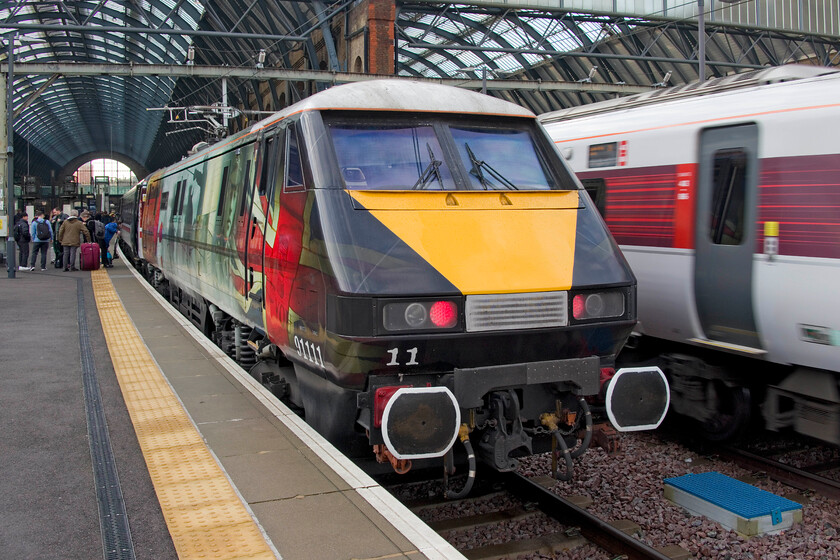 91111, GR 06.05 Leeds-London King's Cross (1A04, 16L) & 800105, GR 05.26 Newcastle-London King's Cross (1Y05, 11L), London Kings Cross station 
 As Azuma 800105 arrives at King's Cross the rear of the 1Y05 06.05 ex-Leeds has already come to a halt and its passengers are seen departing from the train with their luggage. The Leeds train has been powered by celebrity liveried 91111 'For The Fallen' whose vinyl graphics remain as smart as ever. It is pleasing to see the efforts made by depot staff to keep both the remaining IC225 and Azuma stock looking smart and presentable something that BR always struggled to do with the exterior of stock and locomotives looking filthy and unkempt, particularly during the winter months. 
 Keywords: 91111 06.05 Leeds-London King's Cross 1A04 800105 05.26 Newcastle-London King's Cross 1Y05 London Kings Cross station IC225 LNER Azuma For the fallen