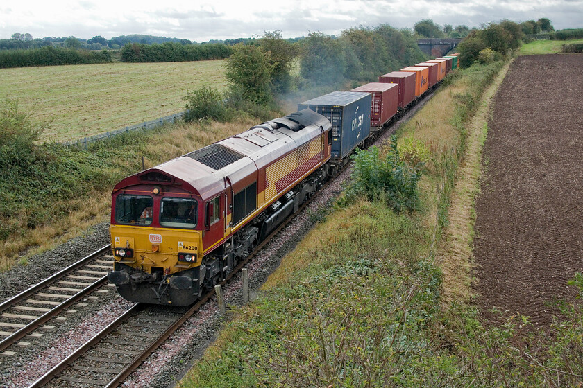 66200, 05.06 Southampton Western Docks-Masborough (4E94, 14E), Willow Bottom Lane bridge SK209088 
 A badly smoking diesel locomotive is not a good look for a modern railway seemingly to trash its environmental credentials. Many of the earlier Class 66s, that are now well over twenty years old, appear to suffer from the malaise of excessive exhaust emissions and 66200, seen here, appears to be one of them. It is seen leading the 05.06 4E94 Southampton to Masborough intermodal working. The rural scene is in the southwestern corner of Staffordshire at the delightfully named Willow Bottom Lane bridge near the village of Harlaston 
 Keywords: 66200 05.06 Southampton Western Docks-Masborough 4E94 Willow Bottom Lane bridge SK209088 EWS DB Cargo