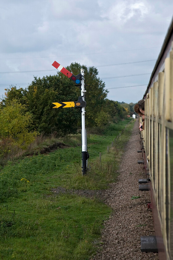 Wansford distant signal, from 10.50 Peterborough Nene Valley-Wansford (2M45), Ailsworth TL109979 
 I normally position myself lineside on the other side of Wansford's home signal looking back towards the train when visiting the Nene Valley Railway, for example, see.... https://www.ontheupfast.com/p/21936chg/30013191656/x60074-13-30-peterborough-nene-valley However, today I bought a ticket to ride so this alternative view of the Wansford distant signal makes for a change. I am travelling aboard the 10.50 Peterborough Nene Valley to Wansford service hauled by 50026 'Indomitable'. The white building in the very distance is not a signal box as it appears but a small structure associated with the NVR's recreation of the TPO lineside exchange apparatus. 
 Keywords: Wansford distant signal 10.50 Peterborough Nene Valley-Wansford 2M45 Ailsworth TL109979 upper quadrant