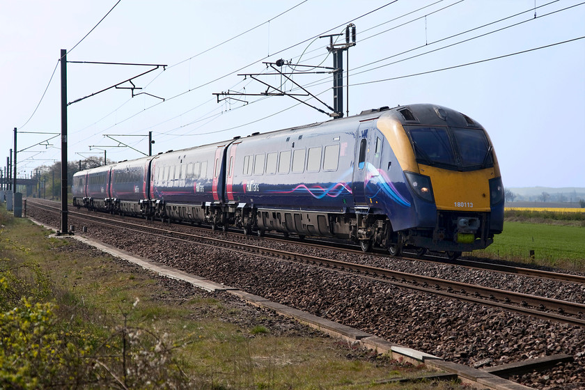 180113, HT 09.48 London King`s Cross-Hull (1H02, 1L), Eaton Lane crossing SK723779 
 A little into the light but still a nice picture of Hull Trains' 180113 at full line speed passing Eaton Lane crossing, where a bridleway crosses the ECML about three miles south of Retford. The five-car Adelante was working the 09.48 King's Cross to Hull where it arrived just one minute late. Reliability of these relatively modern hand-me-down units has not been good to the point where Hull Trains are drafting in HST sets to cover for them whilst extensive modifications are undertaken. 
 Keywords: 180113 09.48 London King`s Cross-Hull 1H02 Eaton Lane crossing SK723779