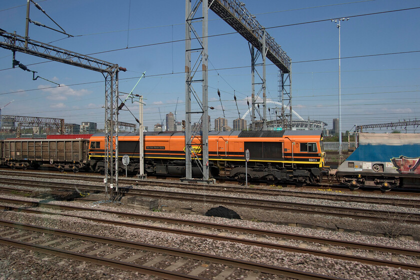 66415, 12.24 Wembley Reception-Merehead (6C77, 222L), Wembley Yard 
 I would have thought that the tucking in of a Class 66 in the middle of two sets of fright wagons may well have been a one-off event as seen here. However, I later read in Rail magazine that this is becoming more common practice in what is probably a cost-saving exercise to return two empty stone trains back to Morehead quarry in one. 66415 'You Are Never Alone' is seen sandwiched in the middle of what would be the 6C77 12.24 Wembley Yard to Merehead with 66528 leading up at the front. 
 Keywords: 66415 12.24 Wembley Reception-Merehead 6C77 Wembley Yard Freightliner You Are Never Alone