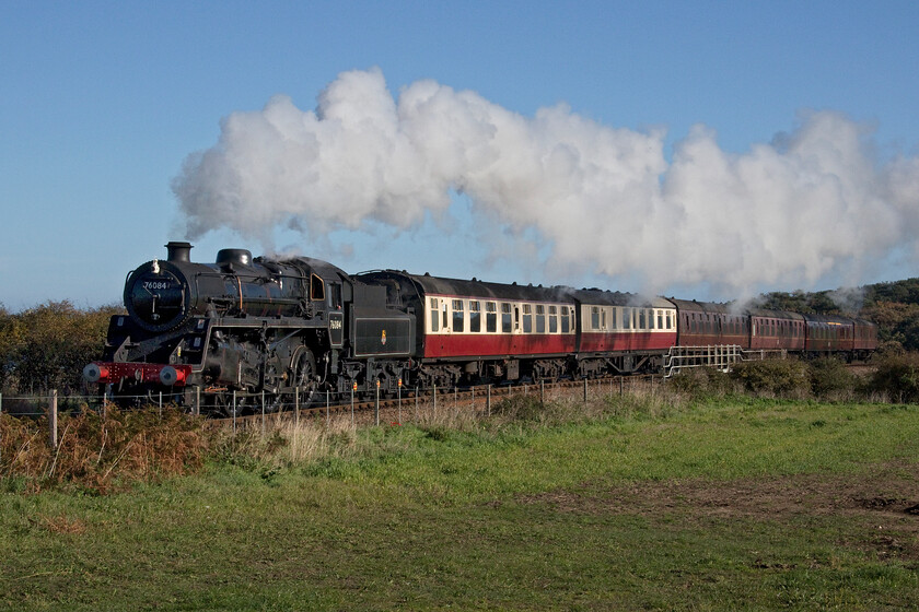 76084, 10.00 Sheringham-Holt, A149 coast road bridge 
 Standard 4MT 76084 leads the 10.00 Sheringham to Holt service in fine style as it crosses the A149 coast road near to Weybourne on Tuesday 18th October 2022. Unfortunately, I am not in quite a high enough position to be able to include the sea that would have been in the background behind the train. The combination of a steam locomotive on a crisp autumn day with the sea must be at the pinnacle of railway photography so it's a shame that the latter is missing in this view. 
 Keywords: 76084 10.00 Sheringham-Holt A149 coast road bridge Standard 4MT