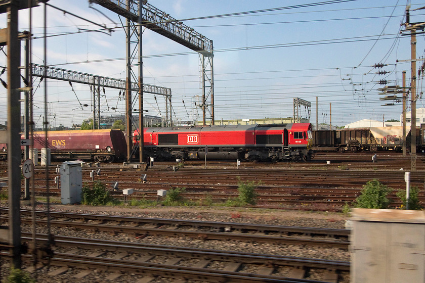 66128, unidentified working, Wembley Yard 
 Taken from the train as we pass Wembley Yard, 66128 is seen at the head of an unidentified up working. Wembley stadium can be seen through the catenary towards the left hand side. 
 Keywords: 66128 Wembley Yard