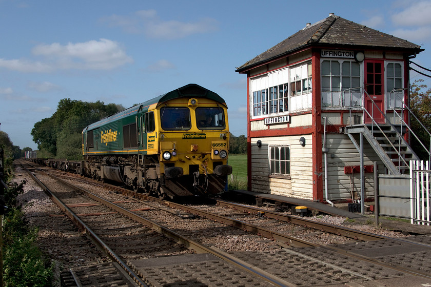 66552, 10.34 Lawley Sreet-Felixstowe North (4L93, 37L), Uffington 
 66552 'Maltby Raider' passes Uffington signal (crossing) box leading the 10.34 Lawley Street to Felixstowe Freightliner. However, on this day, it would probably have been cheaper to take the three containers by road than haul them on an otherwise boxless train apart from the logistics of needing the wagons back at Felixstowe I suppose! I witnessed some unpleasantness between two motorists whilst waiting for the train to arrive where one had pulled in front of another who was waiting first in the queue of cars at the gates. The words exchanged between them were a little fruity! 
 Keywords: 66552 10.34 Lawley Sreet-Felixstowe North 4L93 Uffington Maltby Raider