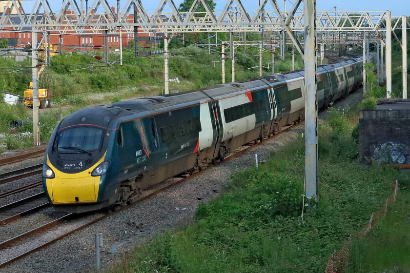 390157, VT 18.53 London Euston-Manchester Piccadilly (1H38, 8L), site of Roade station 
 In some lovely soft evening light 390157 'Chad Varah' works the 1H83 18.53 Euston to Manchester service. It is sobering to think that now in 2024 the Pendolinos have been racking up the miles on the West Coast Mainline for over twenty years. However, this particular example has only been going for twelve years being the last of the extension order to enter service. 
 Keywords: 390157 18.53 London Euston-Manchester Piccadilly 1H38 site of Roade station Chad Varah Avanti West Coast Pendolino