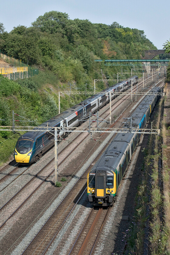 390010, VT 08.43 London Euston-Preston (Cancelled from Wolverhampton) (5S54, 86L) & 350235 & 350246, LN 10.25 Northampton-London Euston (2Z24, 2L), Roade cutting 
 As 390010 'Cumbrian Spirit' heads north through Roade cutting working the 08.43 Euston to Preston whilst 350235 and 350246 head south with the 10.25 Northampton to Euston. The incredibly hot weather affected all trains on this day with a blanket fifty miles per hour speed restriction imposed. The Avanti West Coast train ran into trouble later in its journey arriving at Wolverhampton an hour and a half late and was promptly terminated. Meanwhile, the London Northwestern service was running as a one-off retimed train with the reporting number of 2Z94. 
 Keywords: 390010 08.43 London Euston-Preston Cancelled from Wolverhampton 5S54 350235 350246, 10.25 Northampton-London Euston 2Z24 Roade cutting Cumbrian Spirit