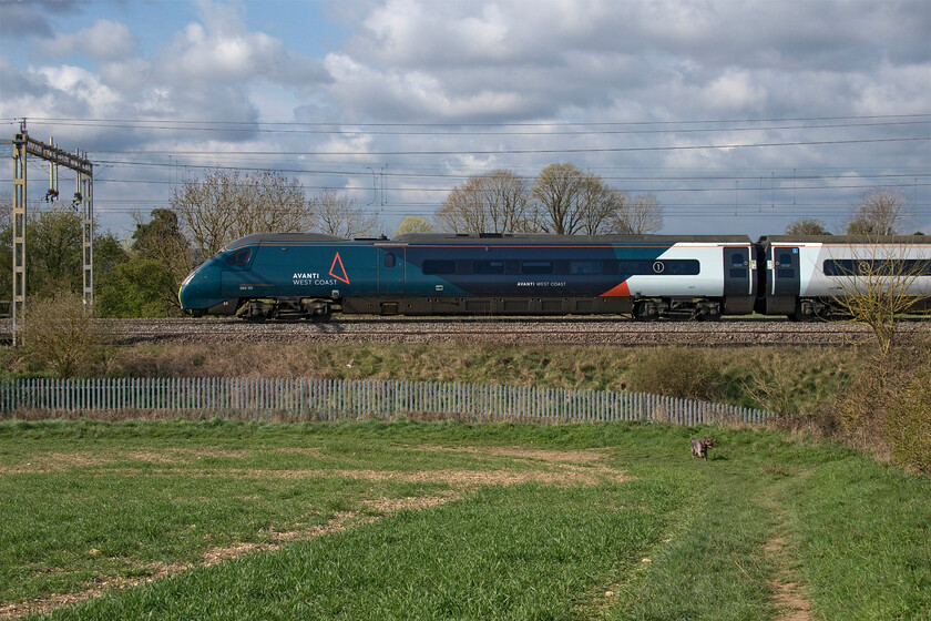 390117, VT 08.05 Wolverhampton-London Euston (1B01, 17L), between Roade & Ashton 
 390117 'Blue Peter' heads south in the early morning sunshine between the villages of Roade and Ashton in Northamptonshire working the 08.05 Wolverhampton to Euston Avanti service. Notice the small dog out for his walk not appearing to take any notice of the passing train. This particular photograph used the camera's maximum shutter speed of 1/2000 sec. to 'freeze' the action. As the train was running fairly slowing this has worked but if it had been at line speed even this shutter speed would not have kept things sharp. By way of comparison, the next photograph adopts the panning technique, see..... https://www.ontheupfast.com/p/21936chg/30013731725/x2-350117-vt-08-05-manchester-p-london 
 Keywords: 390117 08.05 Wolverhampton-London Euston 1B01 between Roade & Ashton Avanti West Coast Pendolino Blue Peter