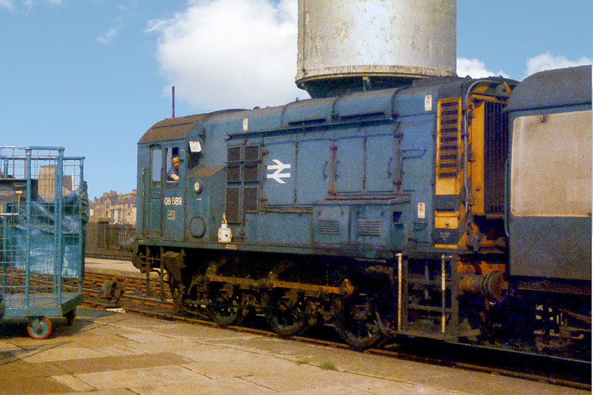 08589, station pilot, Cardiff Central station 
 08589 and its driver sit in the sunshine at Cardiff Central. This shunter was busy as the station pilot moving various wagons and coaches around the environs of the station. 08589 was a Cardiff Canton locomotive all of its life being withdrawn in 1992 and cut-up at Gwent Demolition Margam only a short distance from where it spent this working life. 
 Keywords: 08589 Cardiff Central station