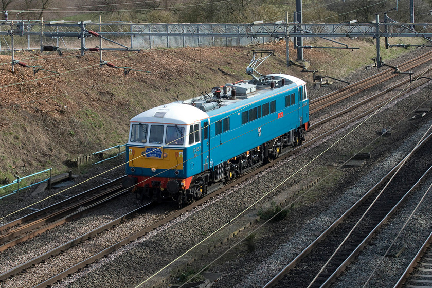 86259, 12.23 London Euston-Rugby carriage sidings LE (0Z89, 13E), Ashton Roade bridge 
 This photograph was taken completely blind in the sense that I was holding the camera as high as I could over the parapet of Ashton Road bridge with the viewing screen tilted down towards me. In this position, I had no warning that the train was coming as I could not see so I had to make accurate use of Open Train Times on my phone and listening for its imminent passage. Luckily, I got things about right as this view of 86259 'Les Ross/Peter Pan' returning to its weekday stabling point at Rugby proves. It was running as 0Z89, the 12.23 ex London Euston. Notice that the locomotive is still carrying its 'Cumbrian Mountain Express' headboard following on from yesterday's railtour duties. 
 Keywords: 86259 12.23 London Euston-Rugby carriage sidings 0Z89 Ashton Roade bridge light engine less Ross Peter Pan