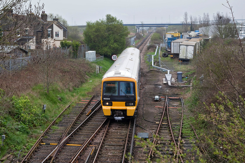 466005, SE 10.05 Sittingbourne-Sheerness-on-Sea (2D27, 10L), Queenborough Main Road Bridge 
 A bit of a head-on shot but there were very limited options due to tree growth. Networker 466005 arrives into Queenborough working the 10.05 Sittingbourne to Sheerness train. Queenborough seemed a nice little place on the Isle of Sheppey that had a well patronised station of traditional construction built by the London, Chatham and Dover railway in 1860. 
 Keywords: 466005 2D27 Queenborough Main Road Bridge