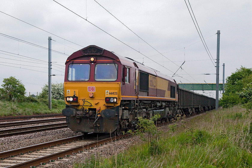 66023, 12.54 Cottam Power Station-Acton (6E46), Langford TL191396 
 66023 ambles along the up slow at Langford in Bedfordshire with the 12.54 Cottam power station to Acton empty wagons. 66023 is still in its EWS livery but all the decals and vinyls have been removed and a single DB logo applied to the front. I wonder how long it will be before a complete makeover takes place? 
 Keywords: 66023 12.54 Cottam Power Station-Acton 6E46 Langford TL191396