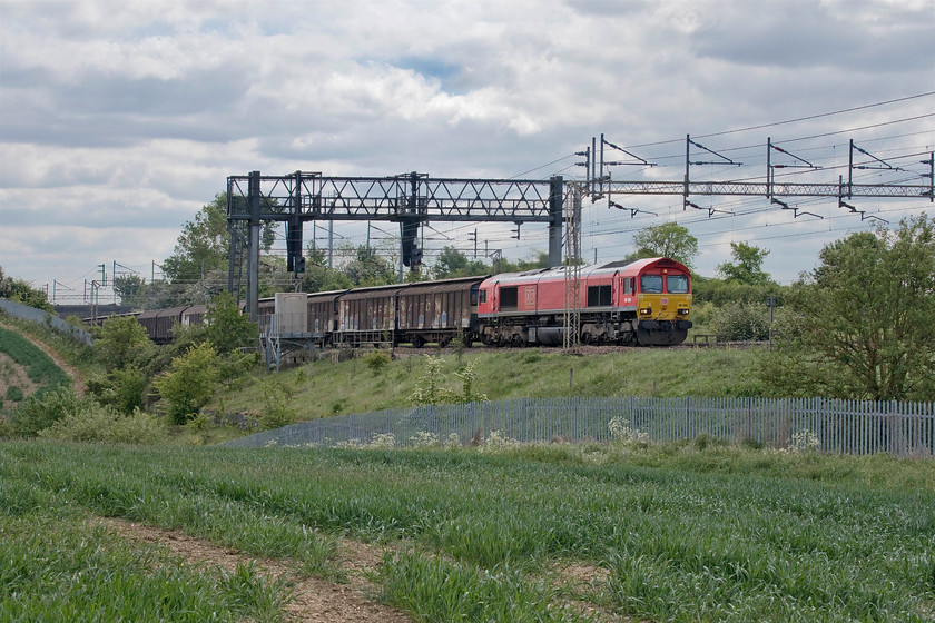 66020, 07.05 Dollands Moor-DIRFT (6M45, 18E), between Roade & Ashton 
 A bit of a grab shot and taken against the light shows 66020 leading the daily 6M45 07.05 Dollands Moor to Daventry. Now operated by DB Cargo UK this locomotive arrived on our shores in October 1998. When twenty-two years old many British Railways first-generation diesels had either been withdrawn from service or were in the process of being so. For example, the entire Western Region Hydraulic fleet or the Peaks. 
 Keywords: 66020 07.05 Dollands Moor-DIRFT 6M45 between Roade & Ashton DB Daventry