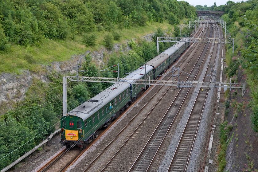 1001, return leg of The Hastings Diesel's Crewe, 17.16 Crewe-Hastings (1Z07), Roade cutting 
 Hastings Diesel's DEMU set 1001 'thumps' its way through Roade cutting with the returning The Hastings Diesels Crewe (sic) charter that left Crewe at 17.16 for Hastings. At the rear is motor car 60118 now named 'Tunbridge Wells'. This car was actually from BR set 1013 that, like a lot of Hastings Diesels' stock, is a composite from a number of withdrawn sets that the group acquired. Notice that the rear of the train does not carry a red light of any sort with the red louvres in the headcode panel deemed suitable. 
 Keywords: 1001 The Hastings Diesel's Crewe 17.16 Crewe-Hastings 1Z07 Roade cutting Hastings Diesel Thumper DEMU