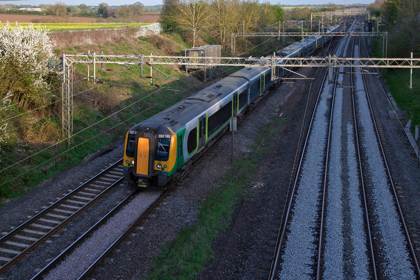 350110 & 350370, LN 17.54 London Euston-Northampton (2N99, RT), Victoria Bridge 
 Victoria Bridge is located between Milton Keynes and Northam[ton on the WCML and is a lovely spot to spend some time recording the passage of trains. Unfortunately, it is still too early in the spring for the line beyond the bridge to be shadow free at this time of the day. So, in the shadows, London North Western 350110 & 350370 pass with the 17.54 London Euston to Northampton. 
 Keywords: 350110 350370 2N99 Victoria Bridge