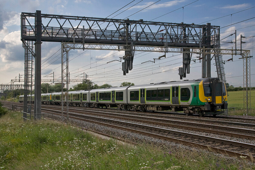 350237, LM 17.13 Birmingham New Street-London Euston (1Y70), Roade Hill 
 350237 and another unidentified unit works the 17.13 Birmingham New Street to Euston London Midland service past Roade Hill. Despite the largely blue sky, this picture has been blighted by a cloud spoiling the moment as the train passed! In order to get this image, a ladder is required to elevate the photographer and the camera above the palisade fencing. 
 Keywords: 350237 17.13 Birmingham New Street-London Euston 1Y70 Roade Hill London Midland Desiro