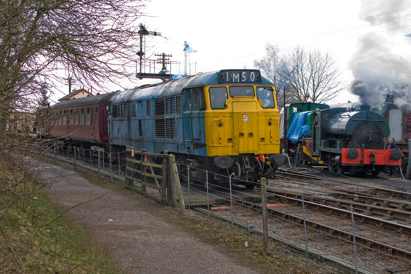 31289, 11.00 Pitsford & Brampton return, Pitsford & Brampton station 
 As resident Peckett 0-4-0 2104 is prepared for service to the right, 31289 heads the Northampton and Lamport Railway's 11.00 return Easter special. It's a shame that the Easter weather was so grey and cold as I am sure that more visitors would have come out and spent their money if it had been better. 
 Keywords: 31289 11.00 Pitsford & Brampton return Pitsford & Brampton station