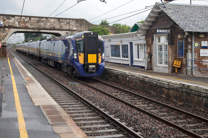 385017, SR 11.12 Edinburgh Waverley-North Berwick (2Y20, 2L), Drem station 
 For the first time since we left our hotel earlier in the morning at Polmont, it has stopped raining! As the milepost makes clear, we are seventeen and three-quarter miles from Edinburgh at Drem station. 385017 is arriving at the station with the 11.12 Edinburgh to North Berwick. Soon, in just over a mile's time, the train will leave the ECML and continue its journey in a northeasterly direction to its destination. I have positioned the train slightly to the left and a little early in the frame to show the station building and North British designed waiting room. There are a number of waiting rooms to this unique design found on this stretch of line and it is good to see them still in use. 
 Keywords: 385017 11.12 Edinburgh Waverley-North Berwick 2Y20 Drem station