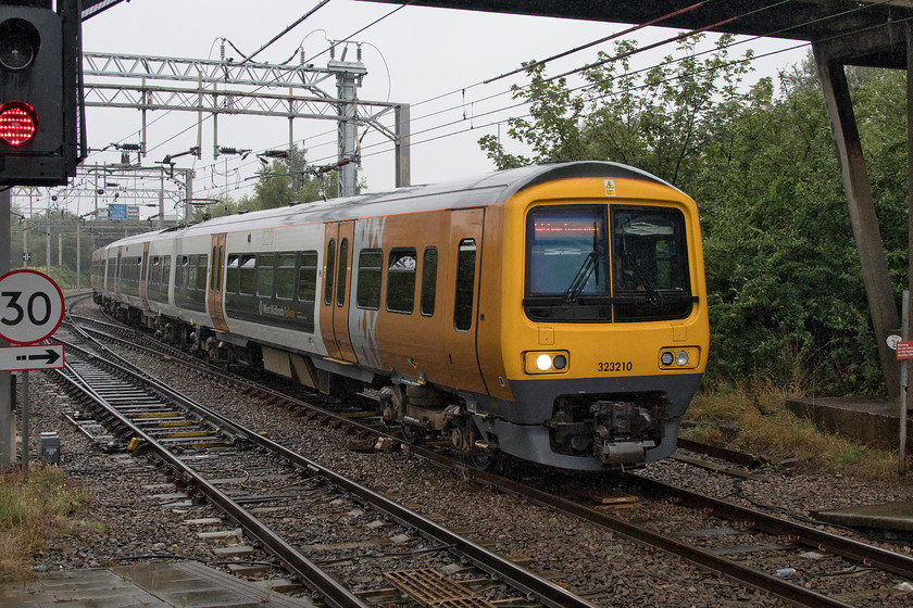 323210, LN 13.31 Walsall-Wolverhampton (2W32, 1L), Bescot Stadium station 
 I like the new livery applied to West Midlands Trains to their ageing class 323 fleet. 323210 arrives at Bescot Stadium station forming the 13.31 Walsall to Wolverhampton. I am taking this picture sheltering from the rain under the footbridge at Bescot Station, something I spent the day doing in a vain attempt to stay dry! 
 Keywords: 323210 13.31 Walsall-Wolverhampton 2W32 Bescot Stadium station