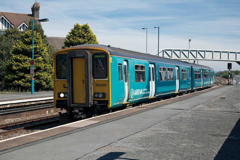 150229, AW 14.00 Swansea-Pembroke Dock (2E24), Llanelli station 
 150229 arrives at Llanelli station forming the 14.00 Swansea to Pembroke Docks afternoon service. It had turned into a glorious hot afternoon in west Wales but I suspect the passengers in the crowed class 150 with no air conditioning and only opening bin windows did not enjoy the heat so mush as Andy and I did! 
 Keywords: 150229 14.00 Swansea-Pembroke Dock 2E24 Llanelli station