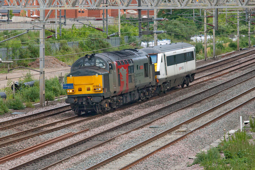 37611 & 82107, 10.44 MNR-Leicester LIP (5Q59, 22E), site of Roade station 
 I had been tracking this movement all day since it left the Mid Norfolk Railway observing various postings to identify exactly what it was. After a slow journey from Norfolk, 37611 'Pegasus' leads former Greater Anglia DVT 82107 past Roade heading towards the Class 37's Leicester base. I am not sure as to why the formerly stored DVT was making the journey. If anybody can advise that would be useful. Whilst I am not complaining, I do not understand why the train took the long route to Leicester that involved the engine changing ends at Nuneaton rather than taking a far more direct route via Peterborough and Stamford? Notice the Rail Operations Group headboard being worn by 37611. 
 Keywords: 37611 82107 10.44 MNR-Leicester LIP site of Roade station Rail Operations Group ROG 5Q59 Pegasus