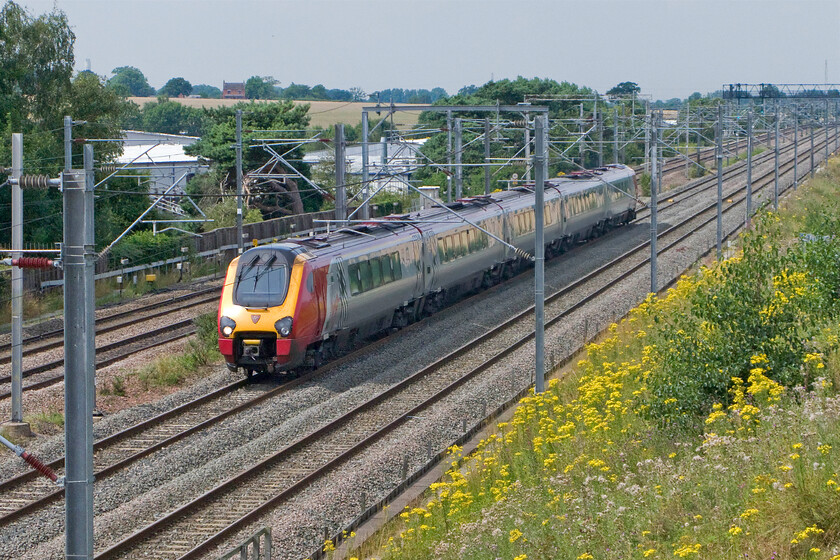 Class 221, VT 12.24 Bangor-London Euston (1A38), Lichfield Nether Stowe footbridge 
 An unidentified Class 221 Voyager heads south on the northern edge of Lichfieldviewd from Nether Stowe footbridge. The Voyager is working Virgin's 12.24 Bangor to Euston 1A38 service. I appreciate that the photograph is taken the wrong side of the bridge for the sun but there was no ability to get the camera through the wire meshing, also, taking it from this side meant that I could include the mass of common ragwort (Senecio jacobaea) on the embankment. 
 Keywords: Class 221 VT 12.24 Bangor-London Euston 1A38 Lichfield Nether Stowe footbridge Virgin Voyager